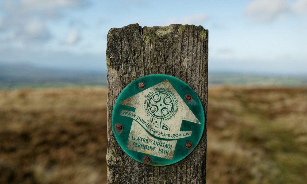 A wooden post with a sign on it, in Pembrokeshire