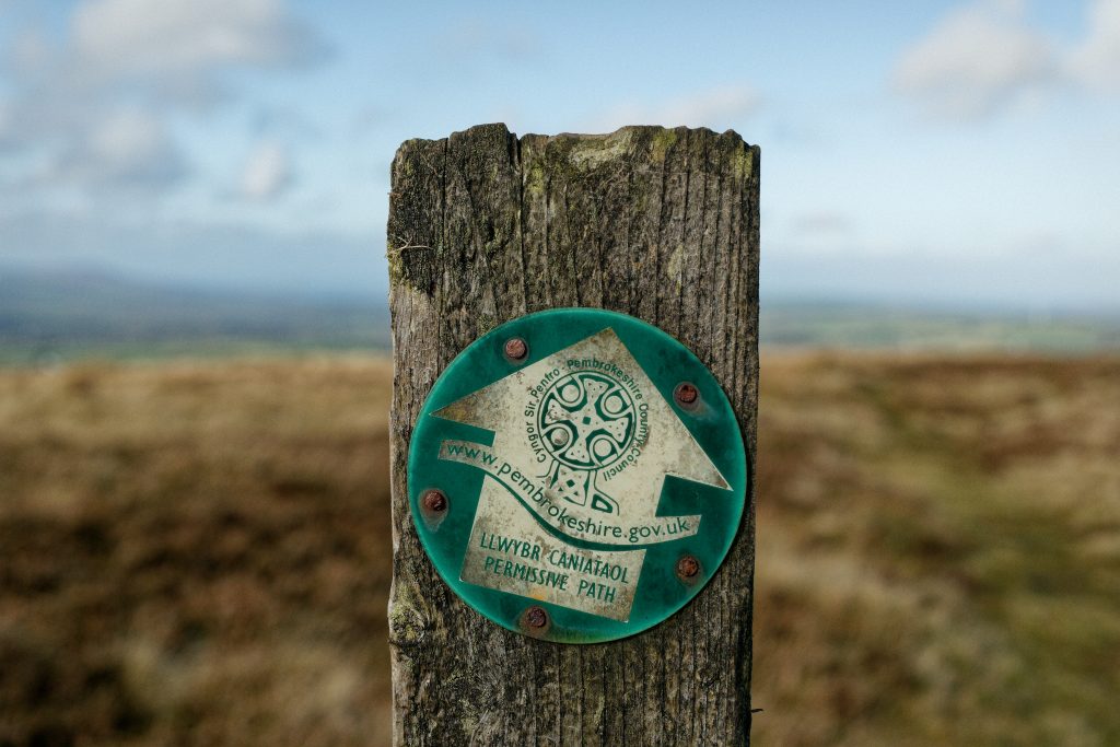 A wooden post with a sign on it, in Pembrokeshire