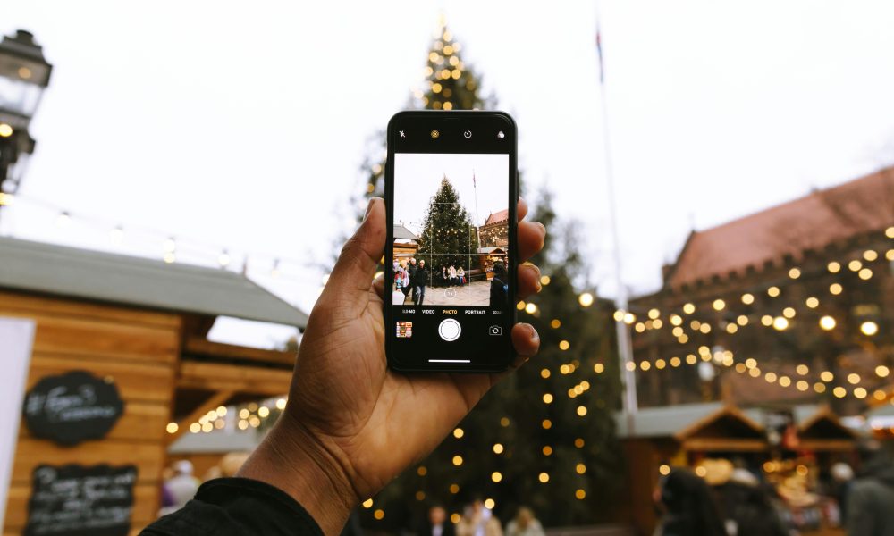 Person Taking Photo of Christmas Tree Using Android Smartphone