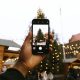 Person Taking Photo of Christmas Tree Using Android Smartphone